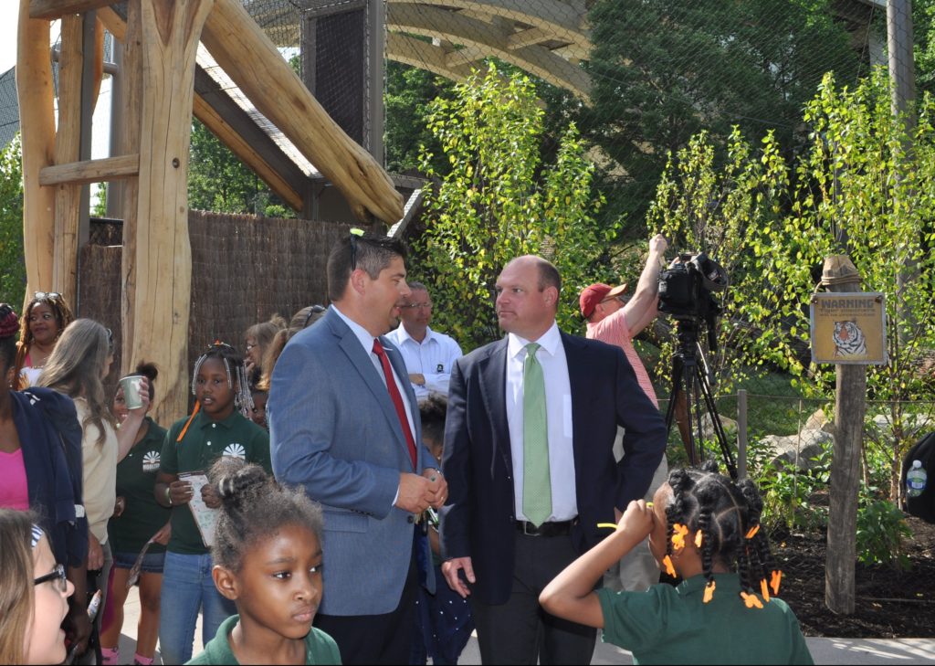 Metroparks CEO Brian Zimmerman and Panzica Vice President Mark Panzica with first visitors in Tiger Passage